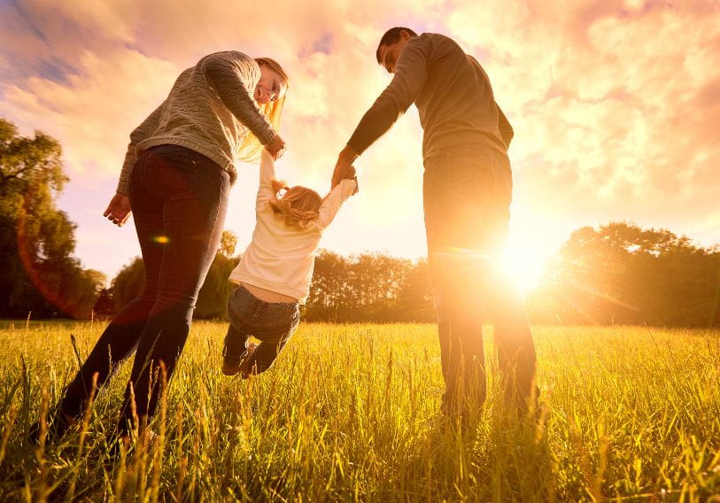 Family and child walking in grassy field