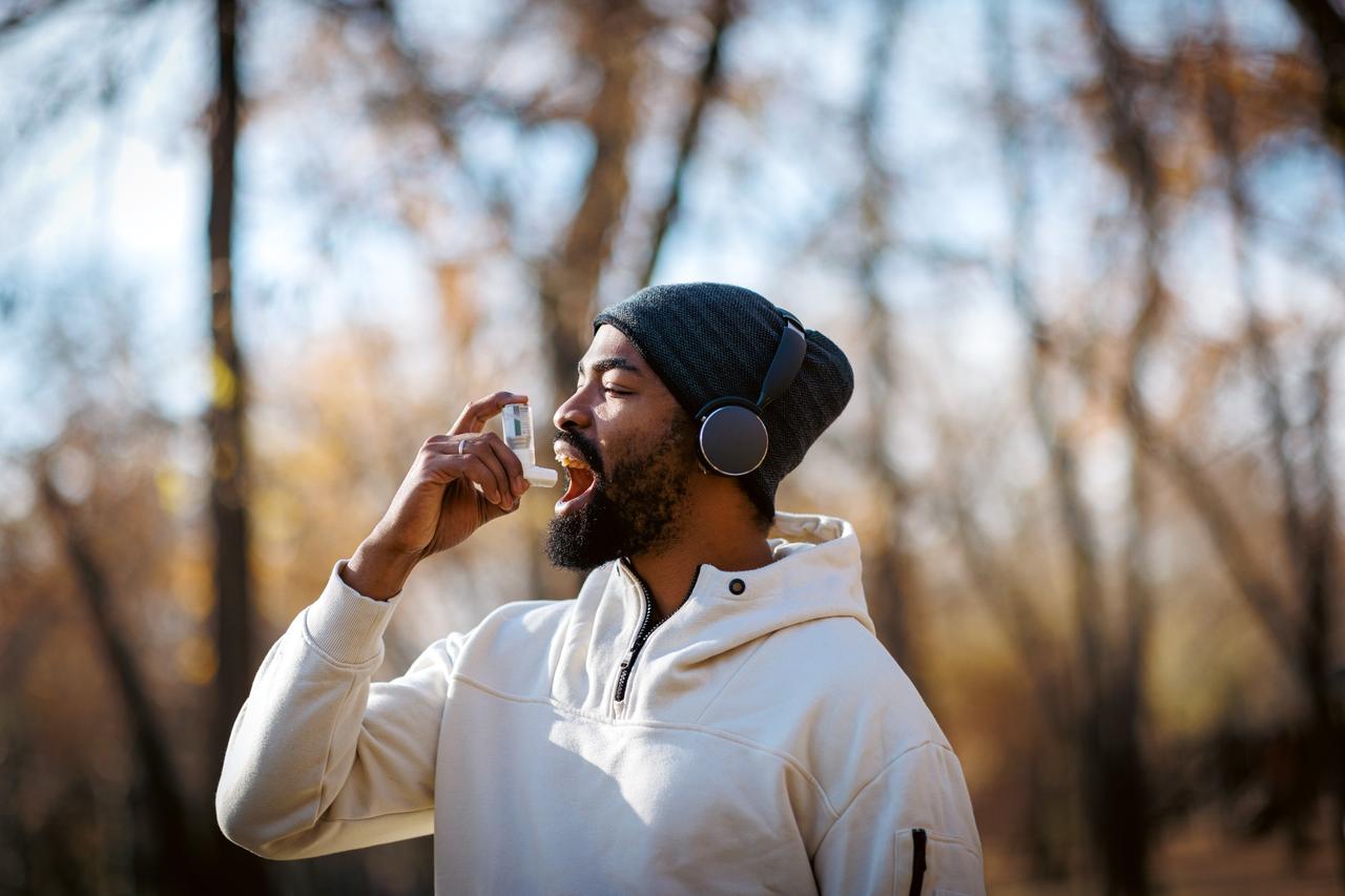 Man using an inhaler outdoors