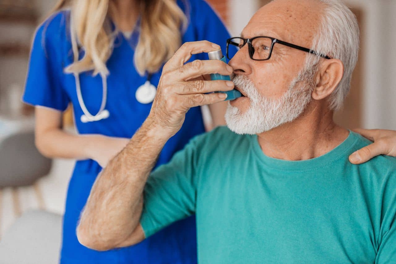 Doctor and man using an inhaler