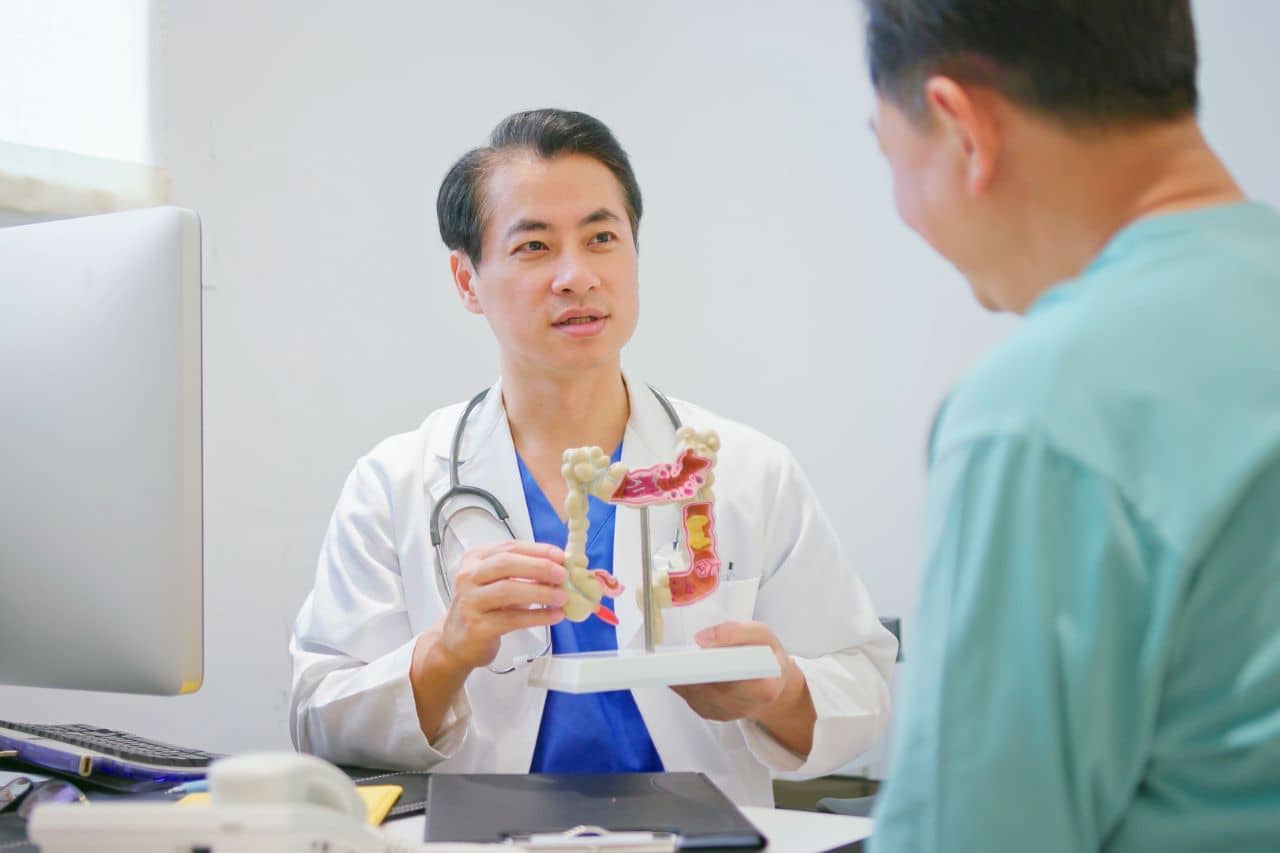 Doctor showing model of colon to a patient