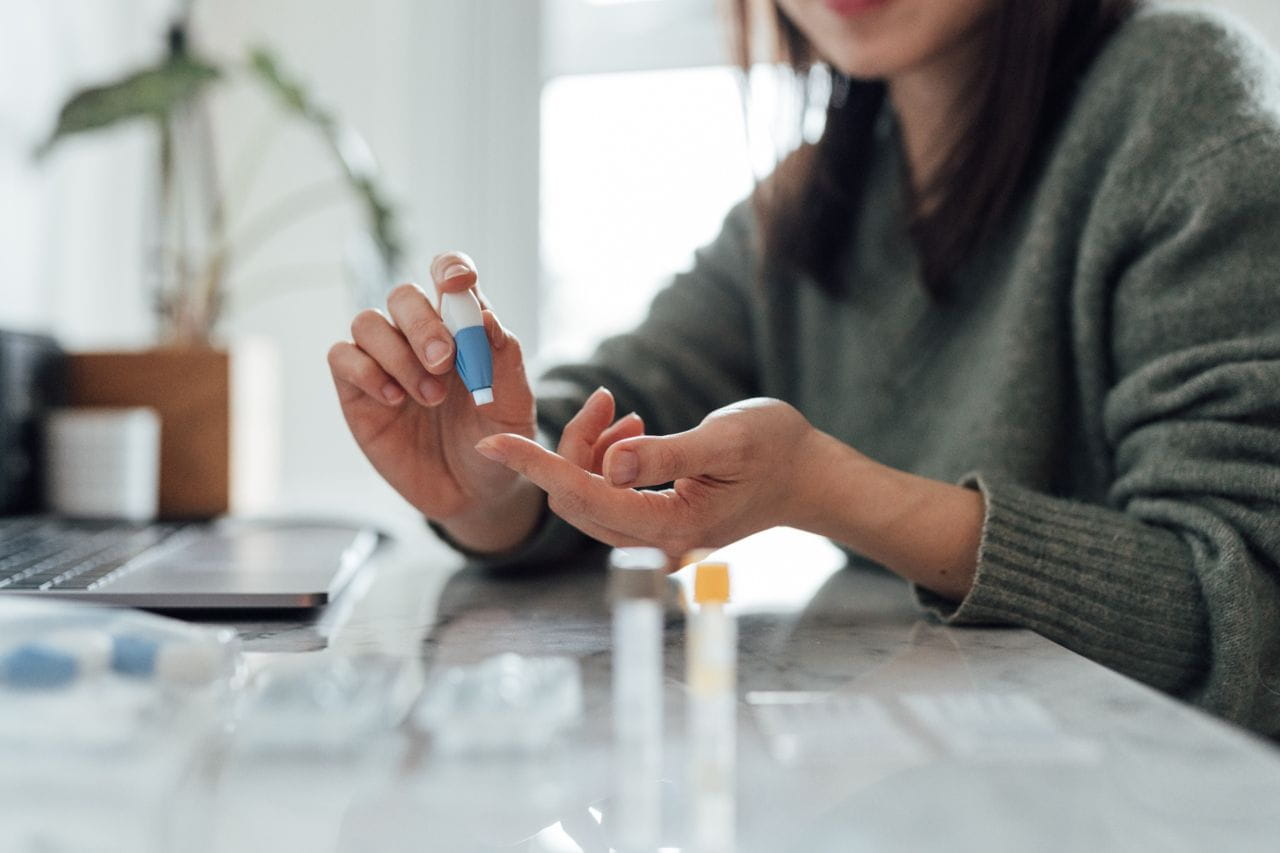 Woman checking blood sugar with finger prick