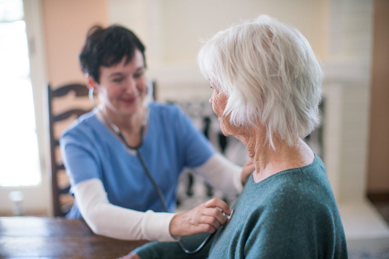 Nurse monitoring the heart of an elderly patient