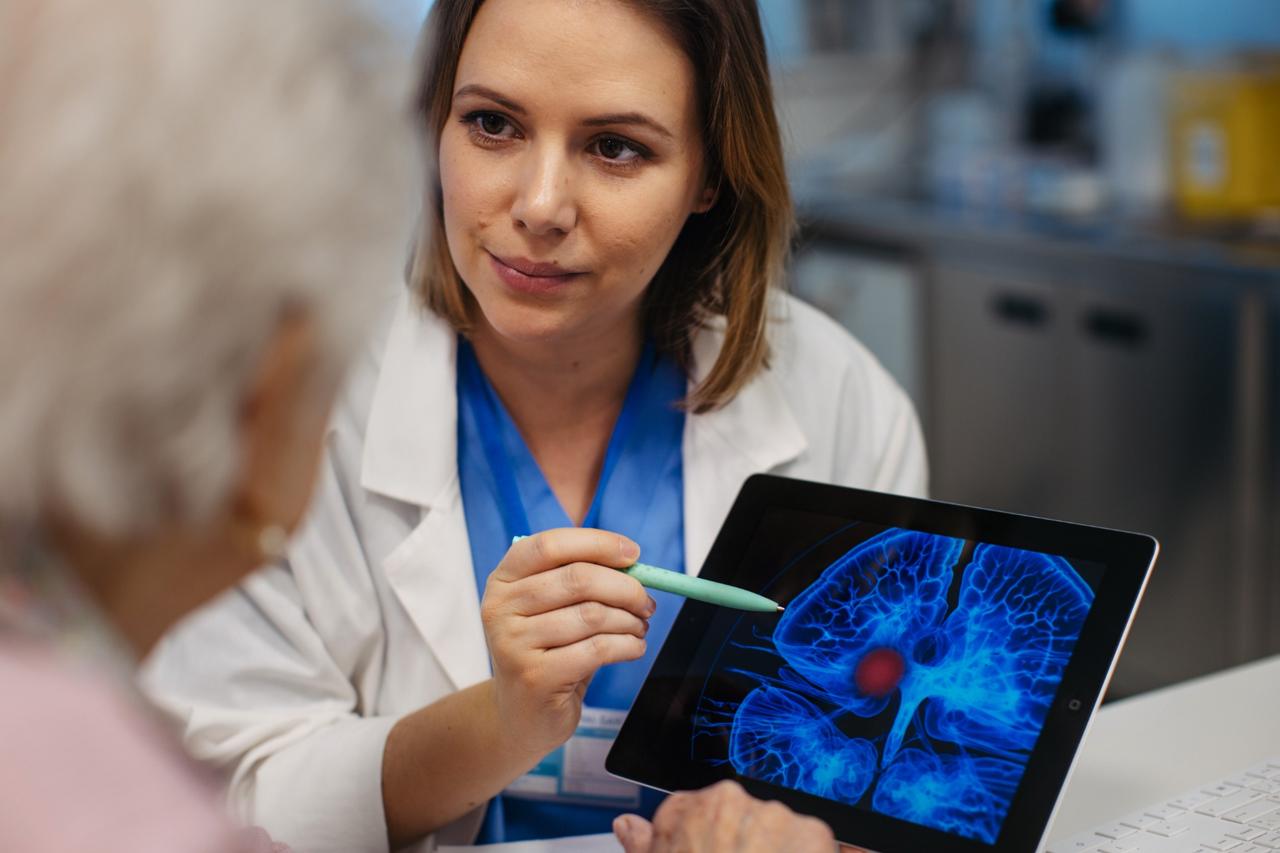 Doctor explaining a brain scan image on a tablet to a patient