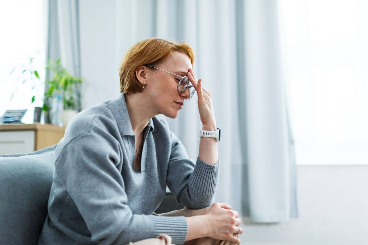 Woman in glasses with a headache