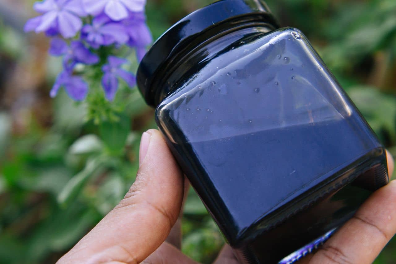 A hand holding a jar of Shilajit Honey