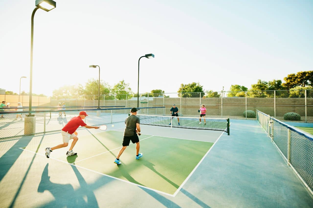 Four different people playing Pickleball