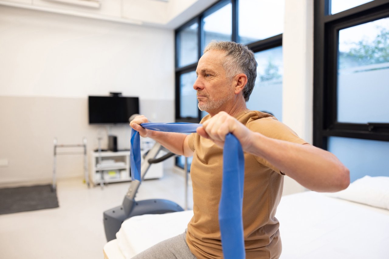 Man doing physical therapy with a blue band