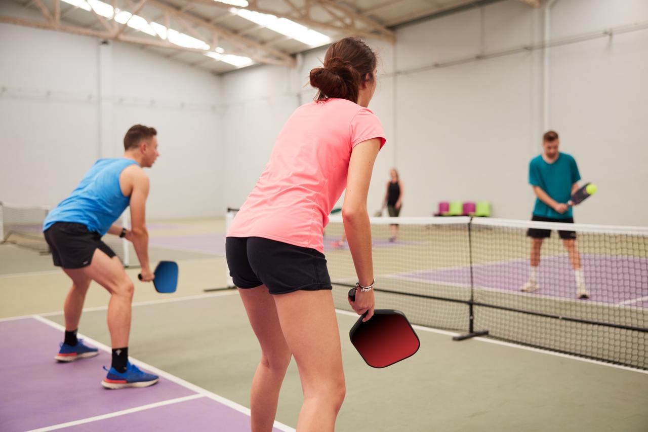 Group of people playing pickleball indoors