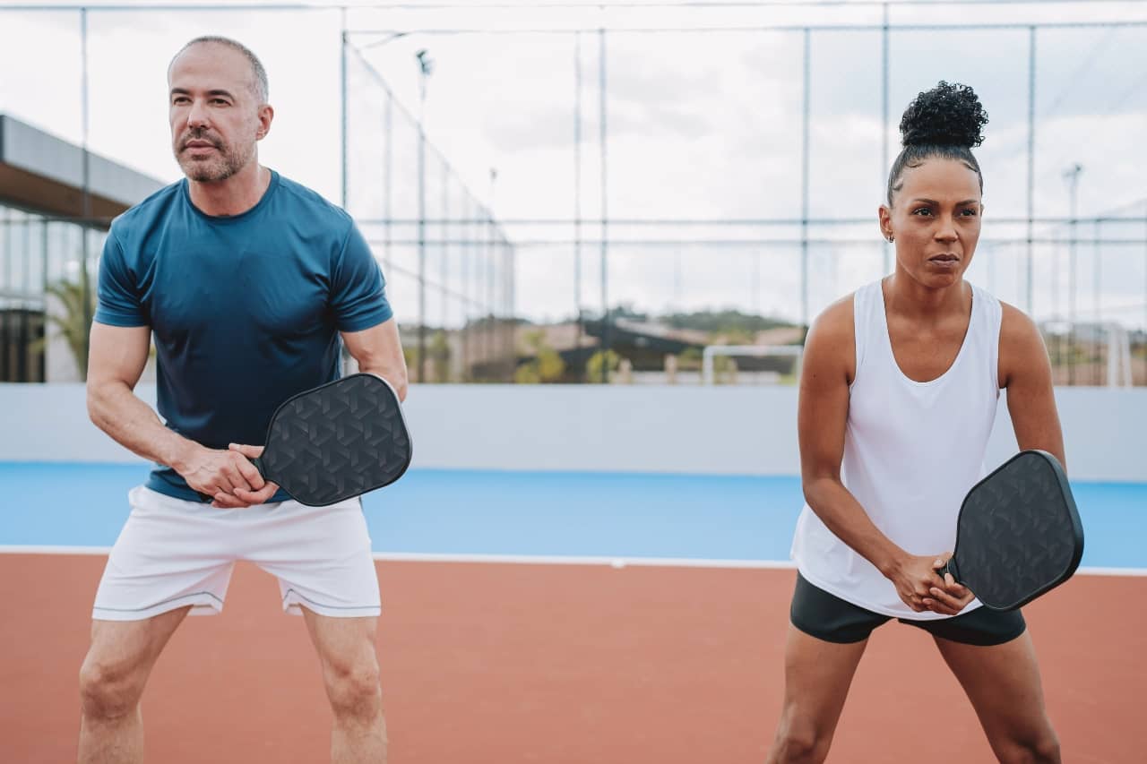 Two pickleball players in outdoor court Physical Therapy