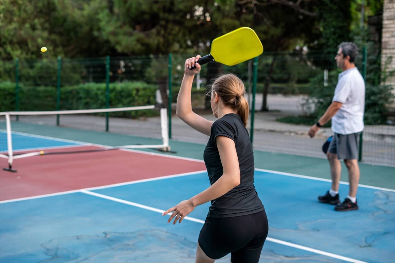 woman and man playing pickleball
