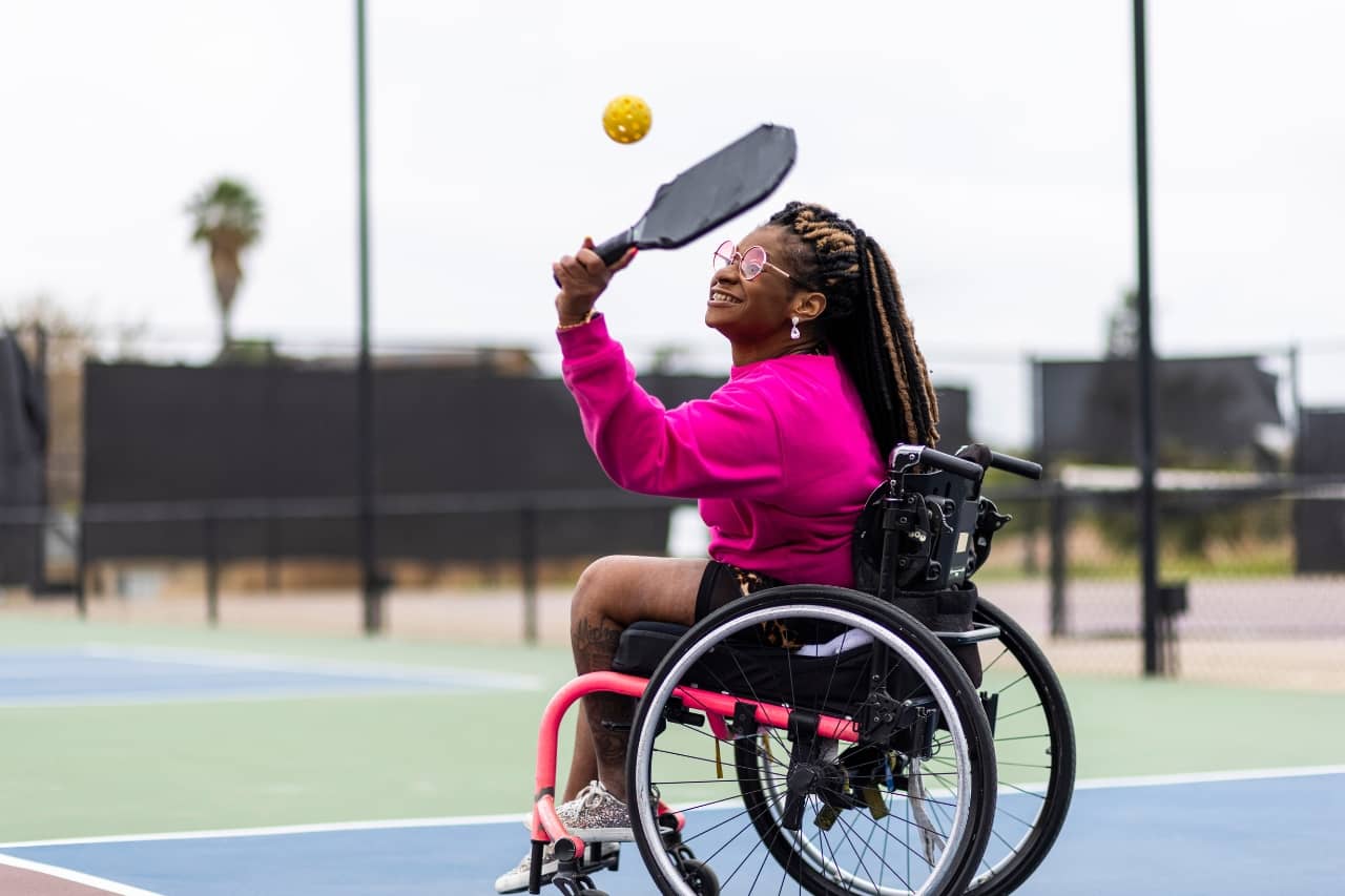 Woman in a wheelchair playing pickleball