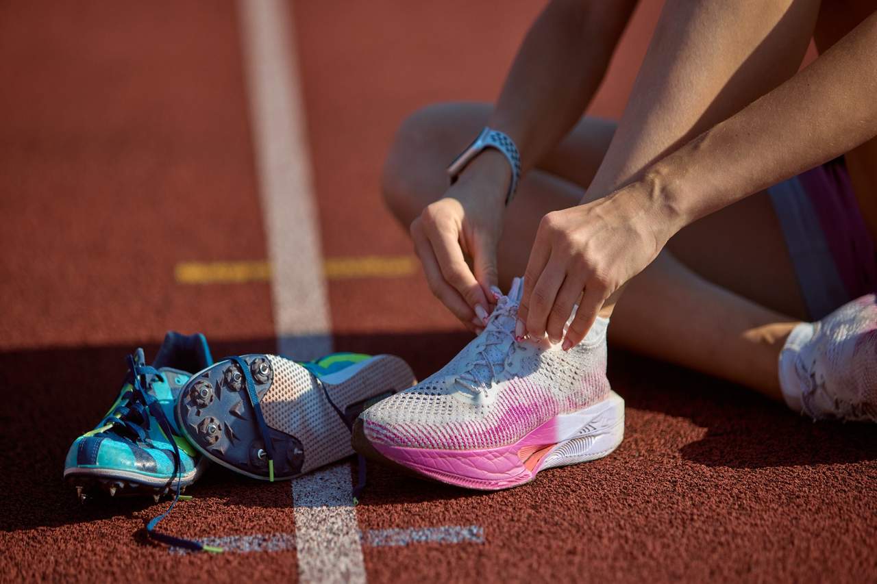 Someone putting on sneakers on a track