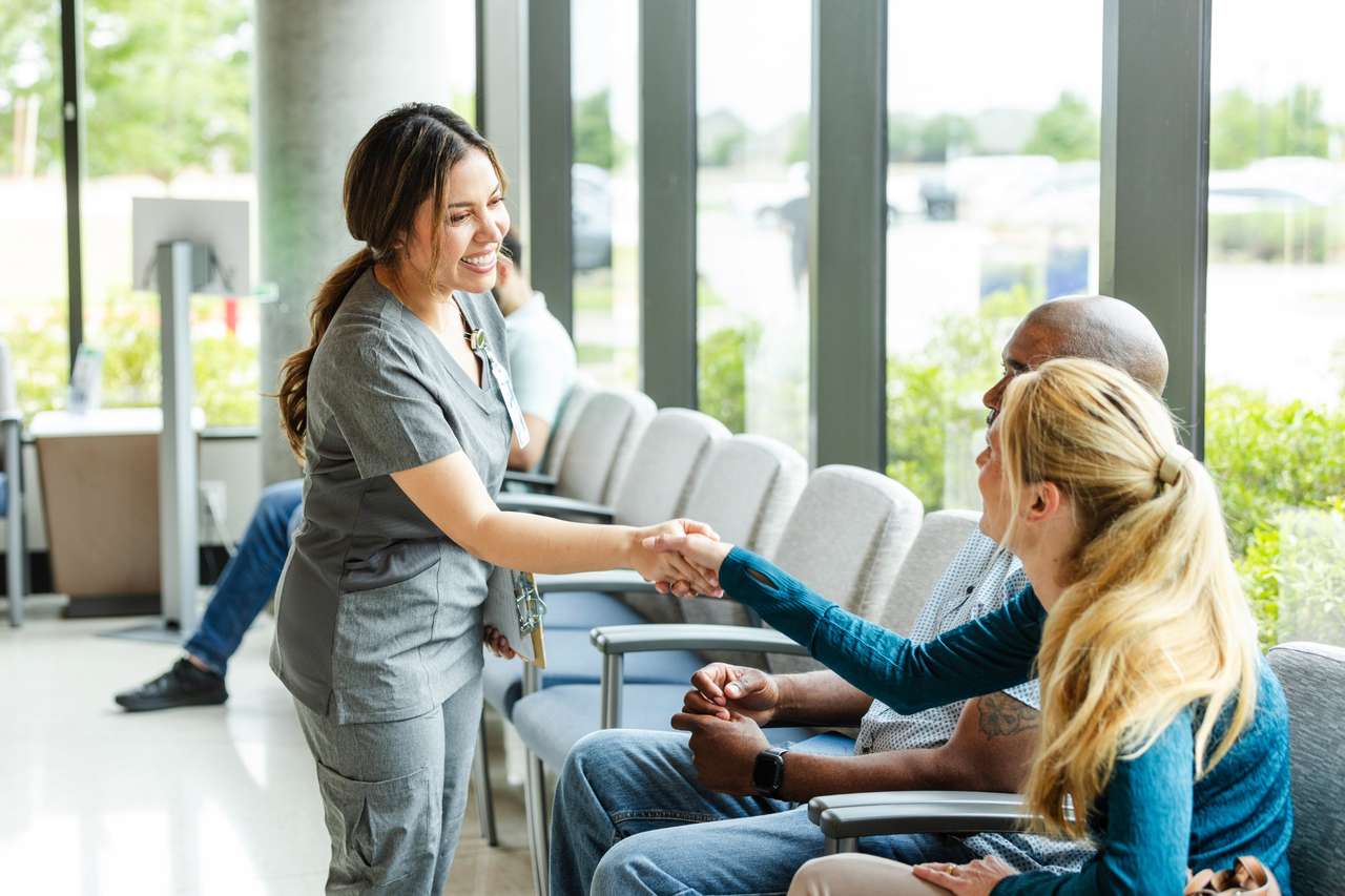 Nurse greeting patients in lobby.